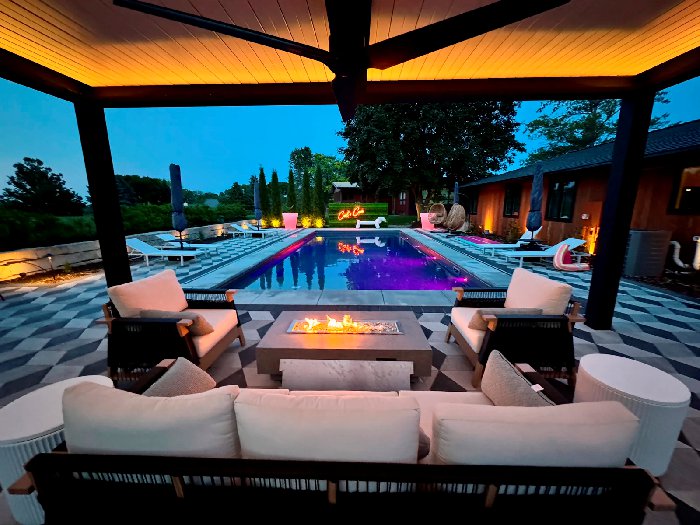 Custom luxury pergola with outdoor seating and fire feature overlooking a pool in Western Minneapolis