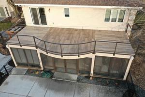 Deck built over a screen porch with curved railing