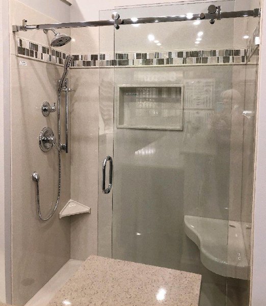New walk-in shower with glass mosaic accent tile and sliding glass door